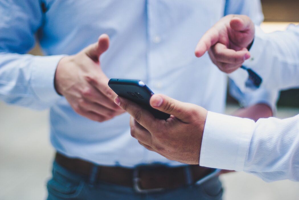 a man holds a phone in his hands and points to it