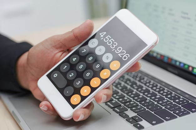 Hand holding an iPhone displaying a calculator app on the screen