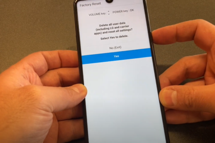 A hand holding an LG Stylo 6 smartphone showing the factory reset screen