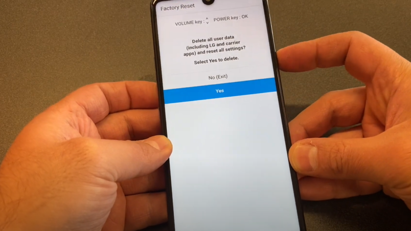 A hand holding an LG Stylo 6 smartphone showing the factory reset screen