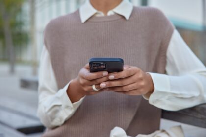 a black woman in elegant clothes holding a mobile phone