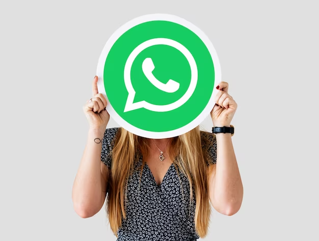 A girl holding an icon of the WhatsApp application